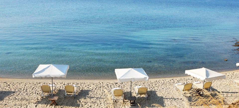 The beautiful beach of Agionissi Resort - the Porto Agio Beach, awarded with the Blue Flag. Umbrellas & sunbeds are free of charge for all our guests.