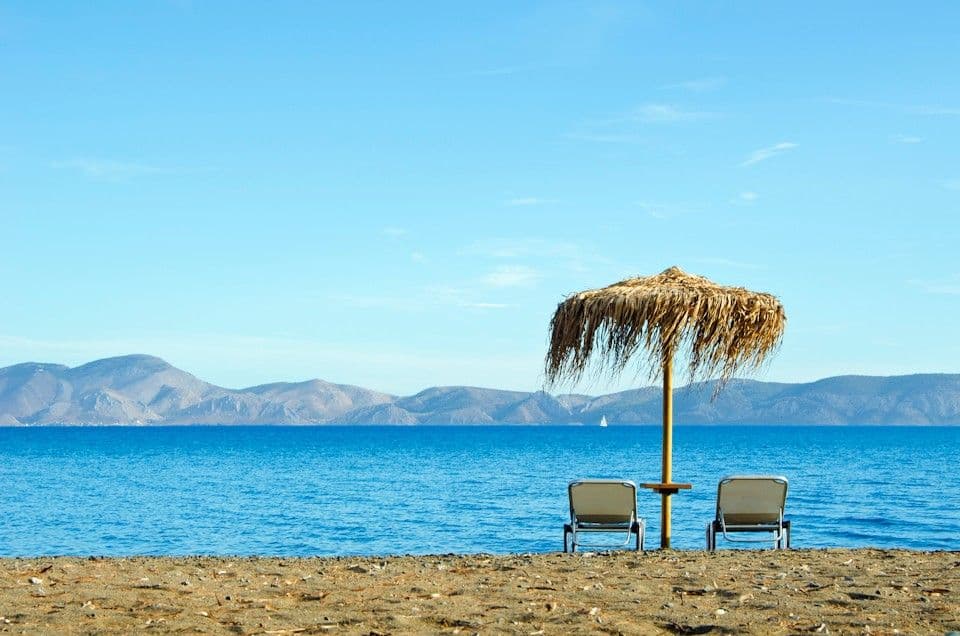 Ξαπλώστρες και ομπρέλες στην ήσυχη παραλία του Makis Inn Resort με θέα Ύδρα και Σπέτσες. Sunbeds and umbrellas on the quiet beach of Makis Inn Resort overlooking Hydra and Spetses. Hydra Spetses Thermisia Ermionida Beach Resort Greece Peloponnese