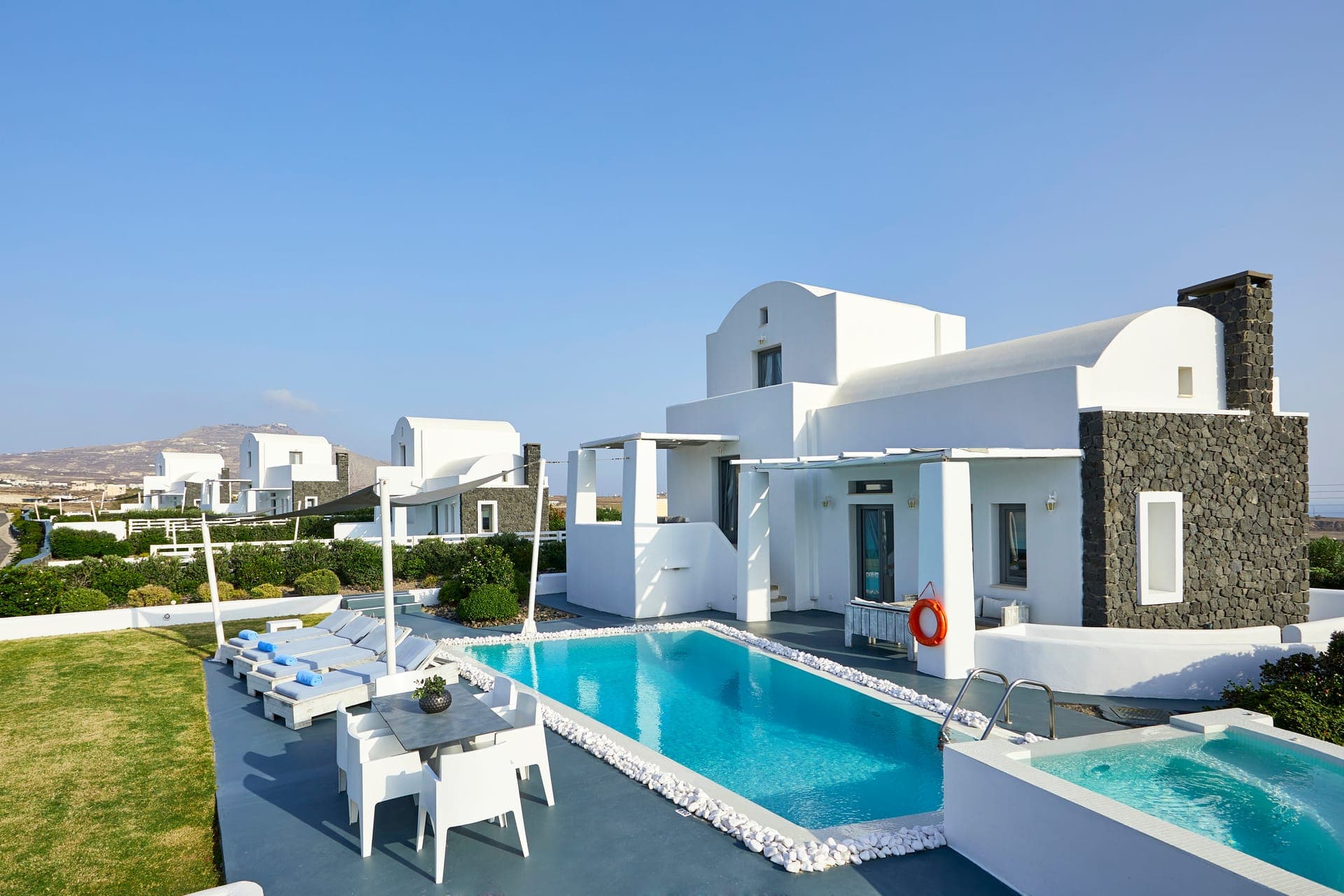 The private garden of the villa with a heated swimming pool, private Hot Tub, Sunbeds and dinner table.