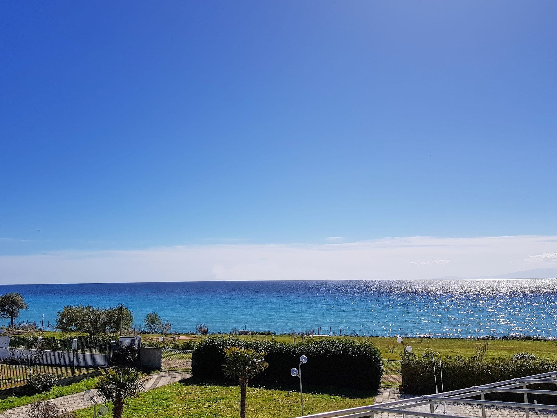 Panoramic seafront view with crystal-clear Mediterranean waters at Skion Palace Beach Hotel in Halkidiki, Greece.