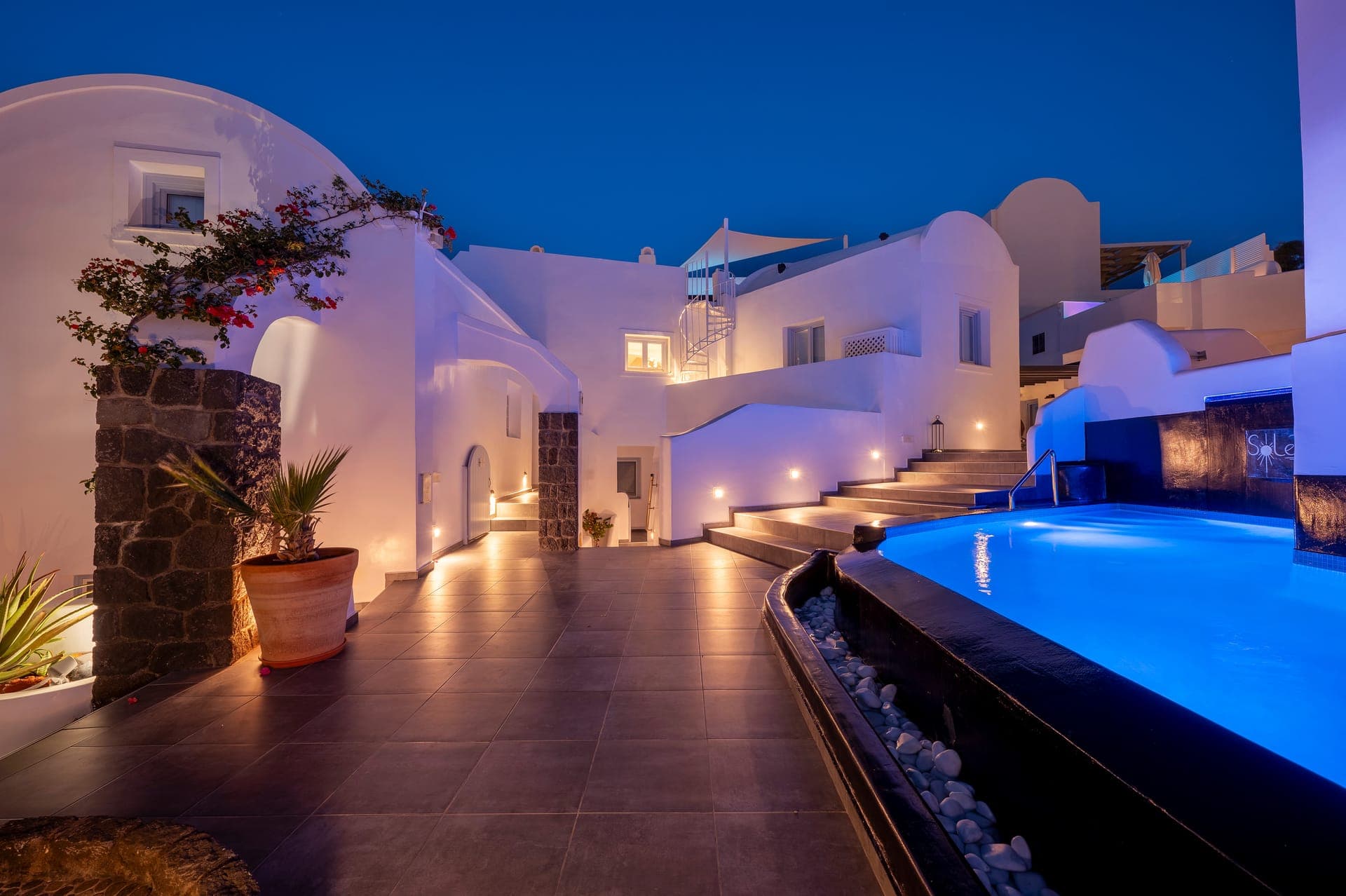 Experience the magic of Oia at night by the glowing private pool of Sole d'oro, where luxury meets traditional Cycladic architecture